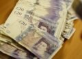 Sterling edges up in holiday trading, still down on the week